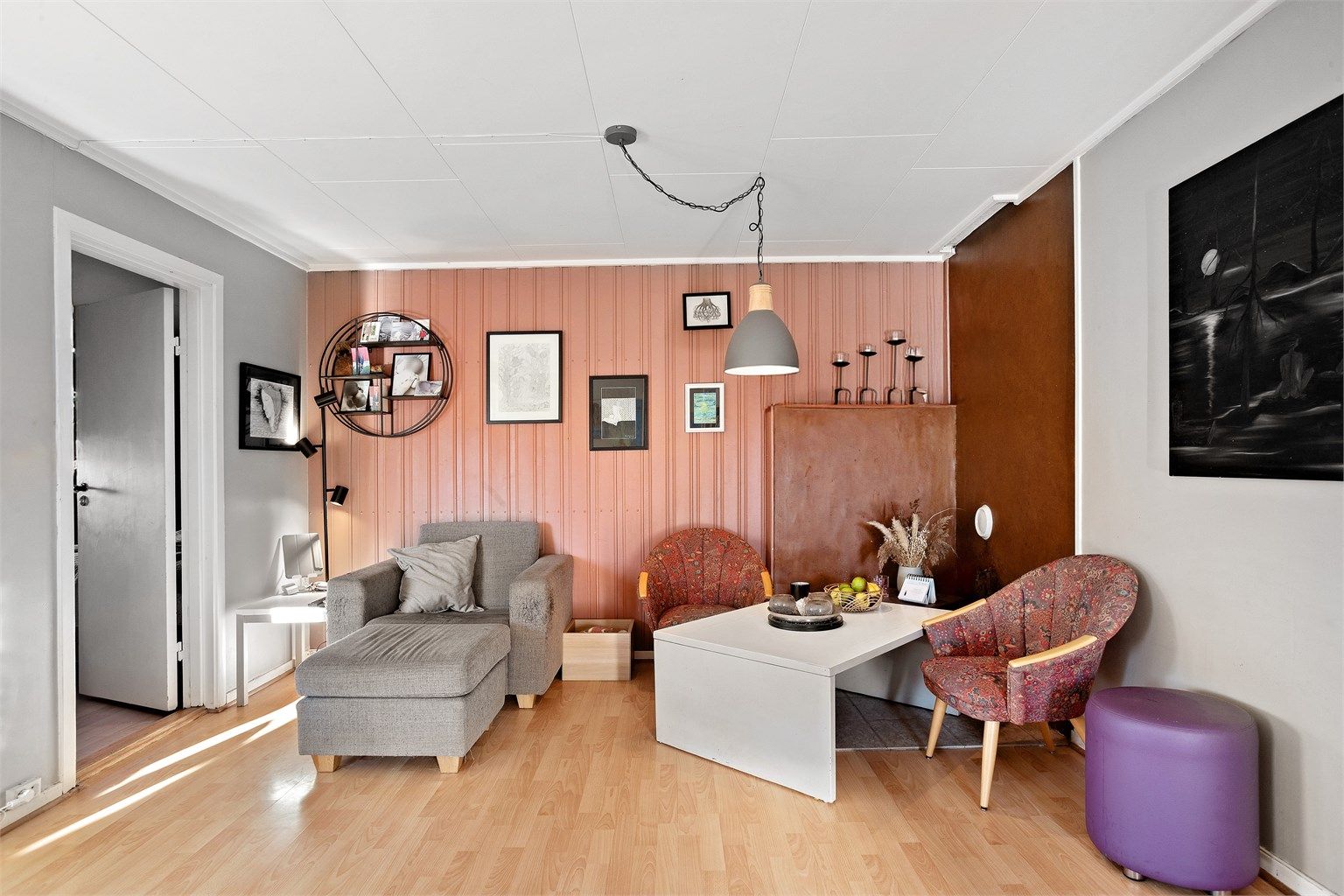 Hyggelig sittegruppe i leilighetens stue med panelte fondvegger.