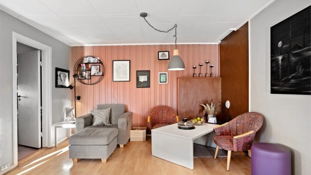 Hyggelig sittegruppe i leilighetens stue med panelte fondvegger.