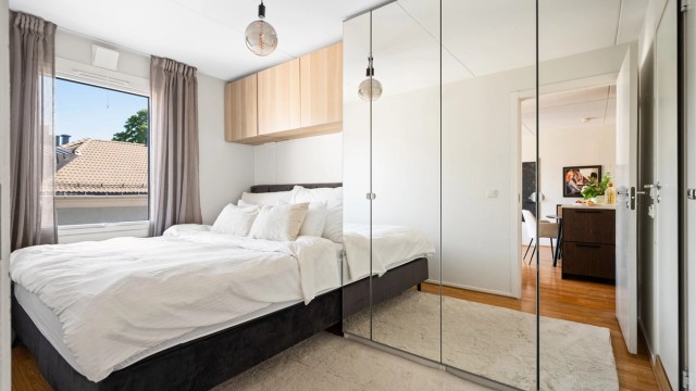 Skyvedørsgarderobe med speilfronter gir rikelig med oppbevaringsplass og bidrar til en lys og romslig følelse.
