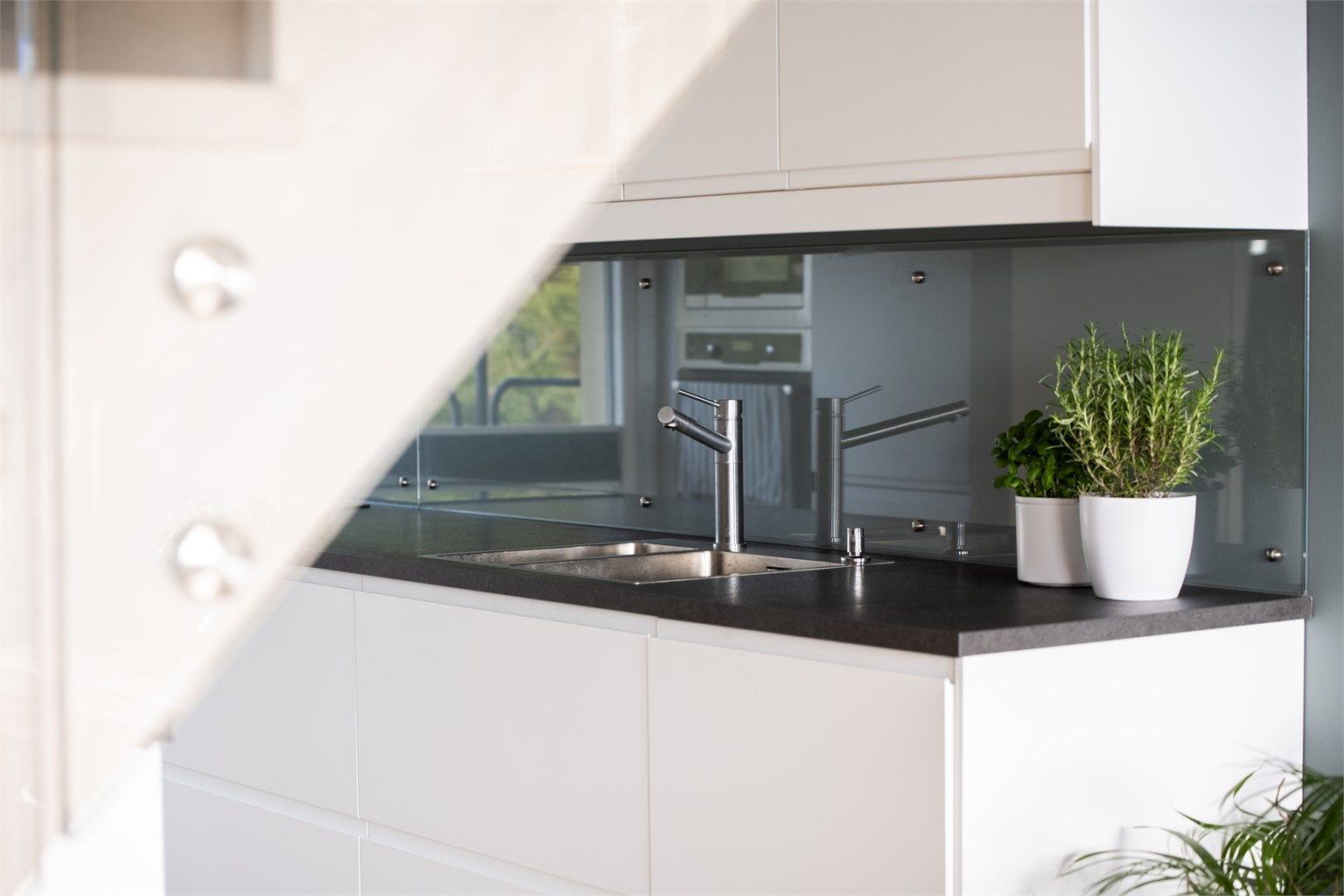 Kjøkkenet er utstyrt med glassplate over benk og nedfelt oppvaskkum i rustfritt stål.