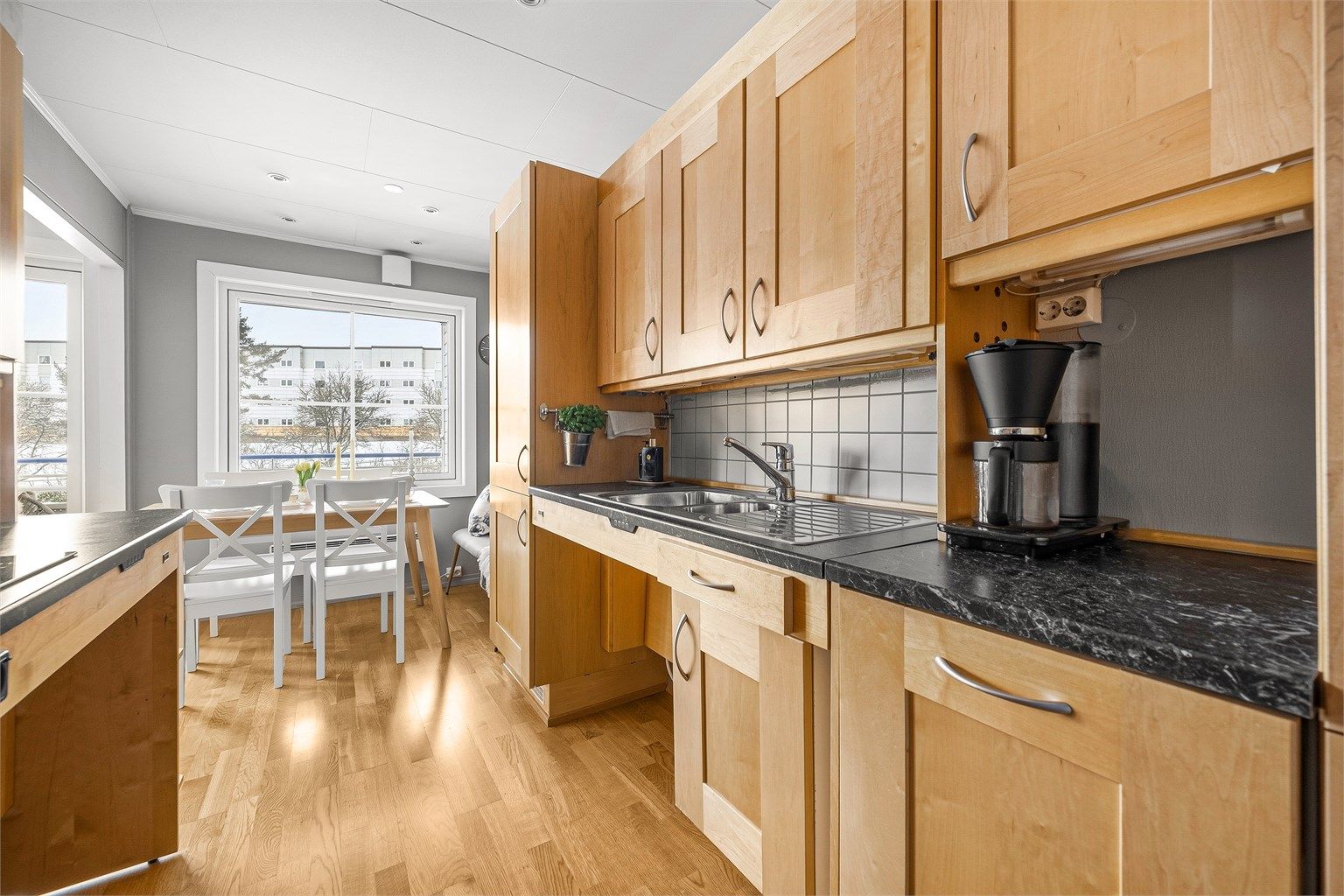 Kjøkkeninnredningen er ergonomisk tilpasset med praktisk hev- og senkefunksjon på benkeplatene.