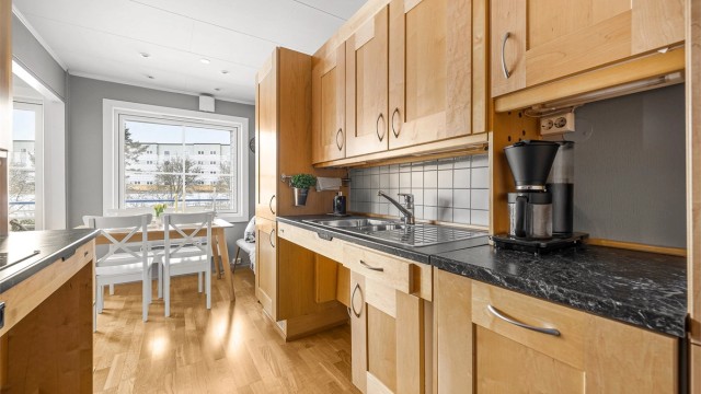 Kjøkkeninnredningen er ergonomisk tilpasset med praktisk hev- og senkefunksjon på benkeplatene.