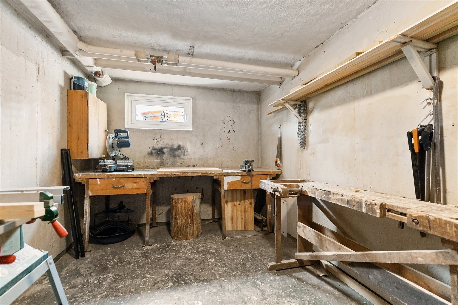 Felles hobbybod i kjeller med god plass til ulike prosjekter og stativ for prepping av ski