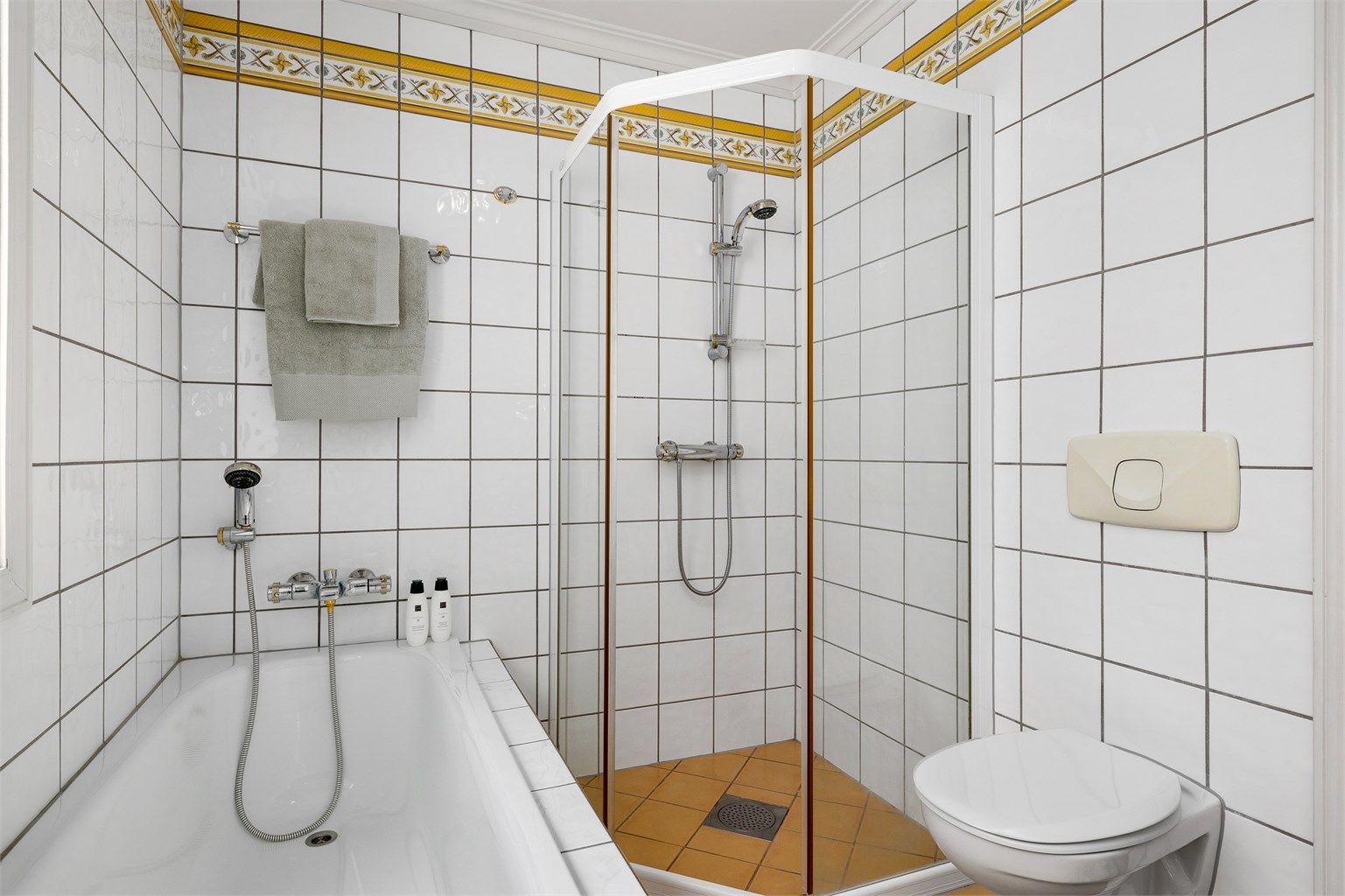 Flislagt bad i 2. etasje med wc, dusj, badekar og 2 servanter med tilhørende innredning.