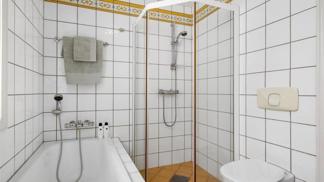 Flislagt bad i 2. etasje med wc, dusj, badekar og 2 servanter med tilhørende innredning.