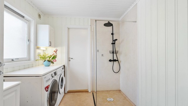 Dusjhjørne med dusjvegger av glass, regnfalldusj og hånddusj.