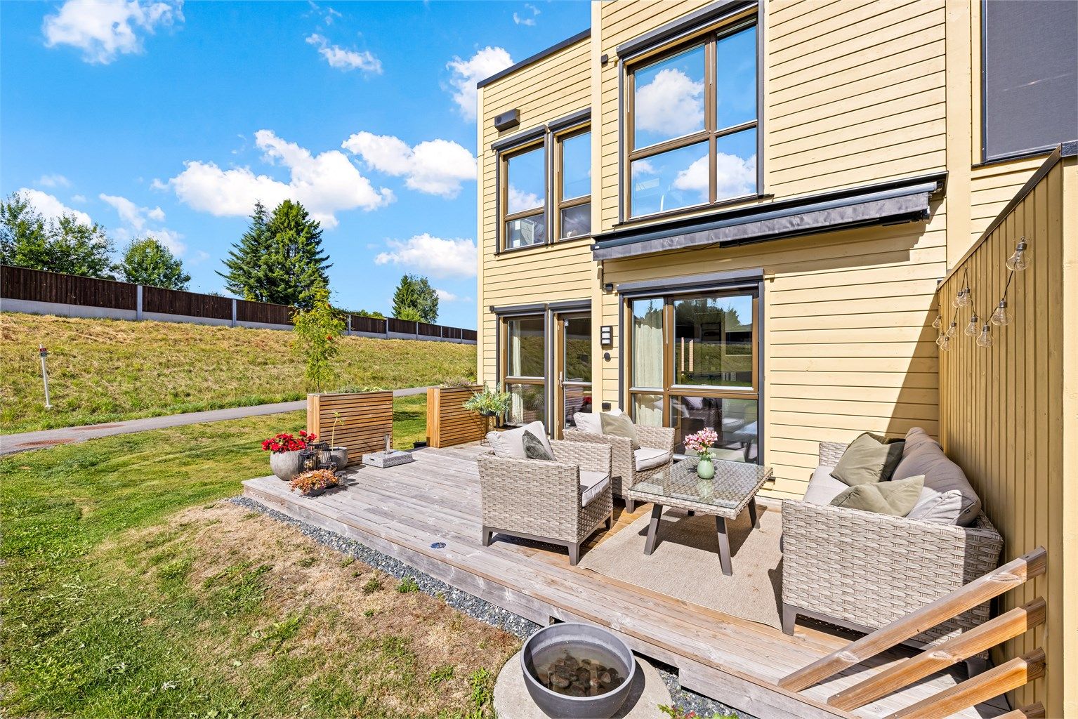 Uteområdet er pent opparbeidet med plen og en terrasse med impregnerte terrassebord.