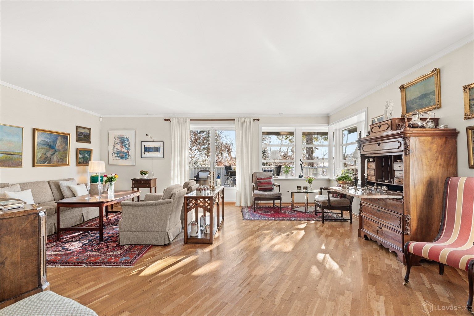 Stuen er romslig med parkett på gulvet og store vindusflater som gir rikelig med dagslys