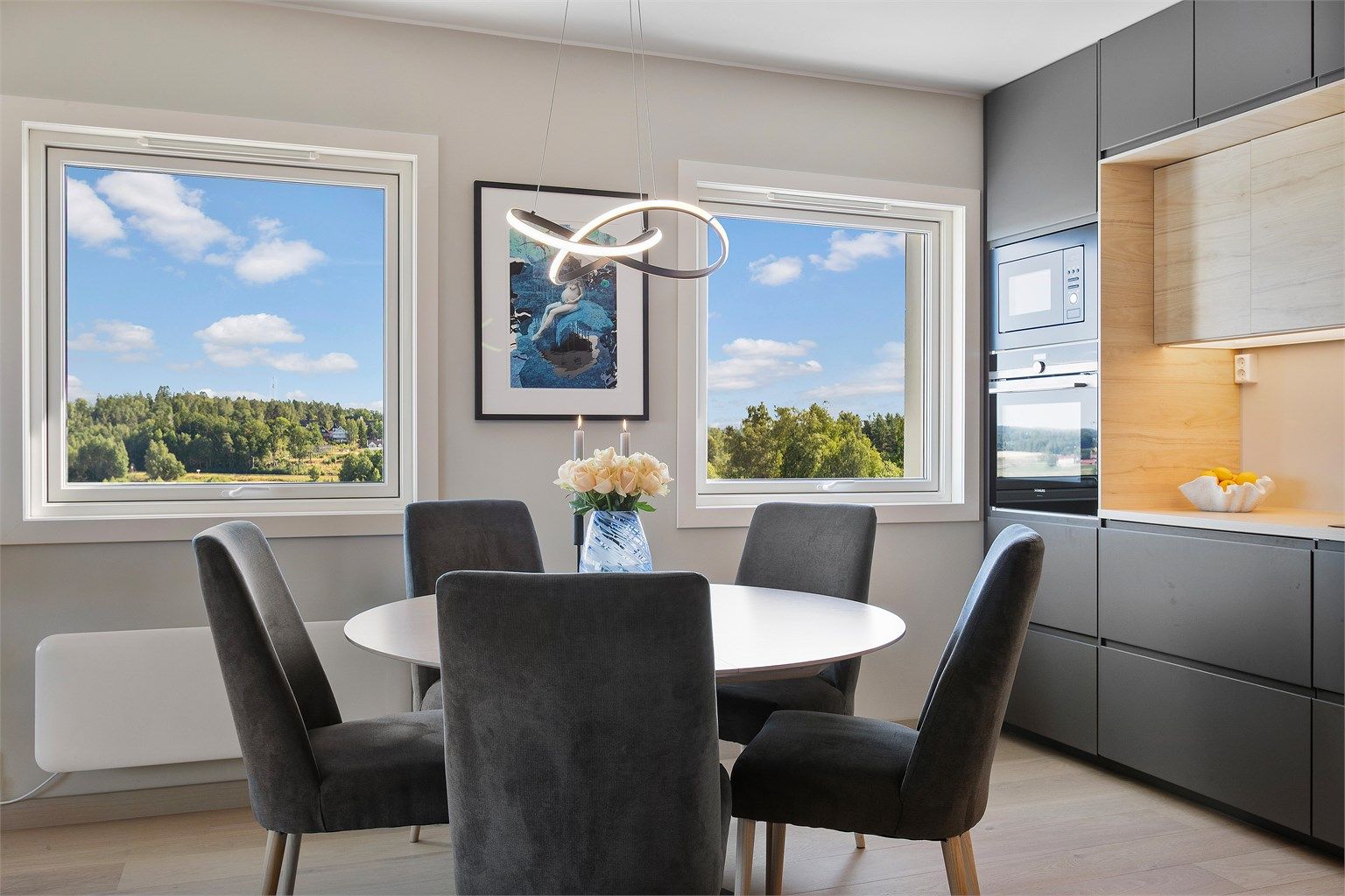 Kjøkkenet fra 2023 har moderne innredning med glatte fronter og laminert benkeplate.
