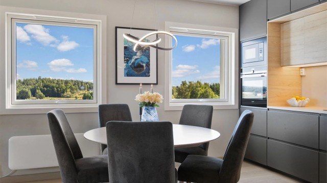 Kjøkkenet fra 2023 har moderne innredning med glatte fronter og laminert benkeplate.