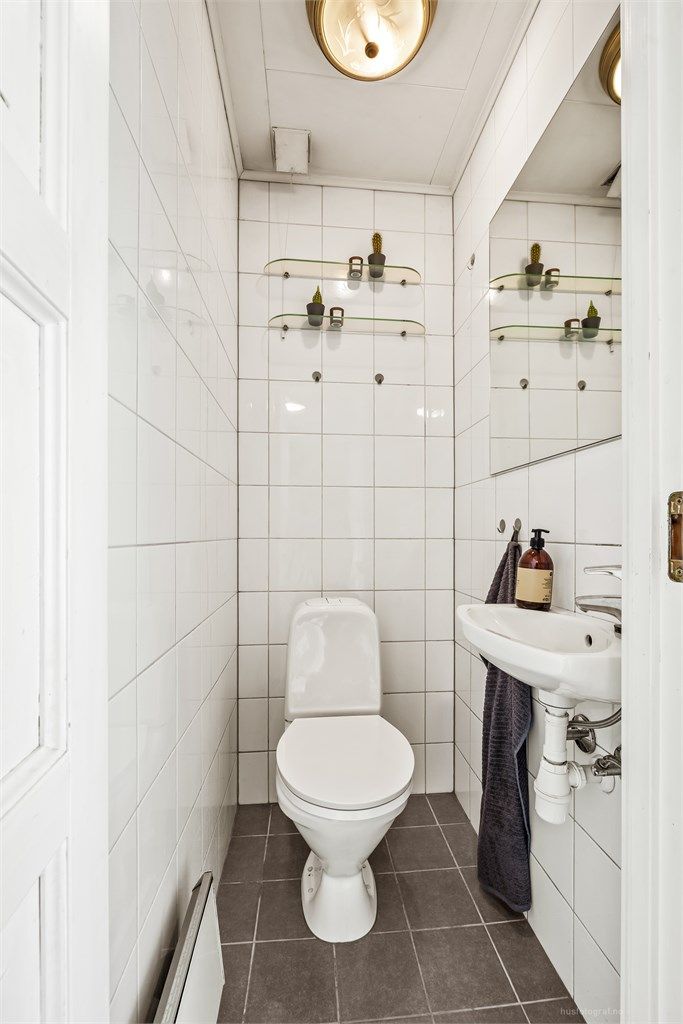 Vegg i vegg med baderommet finner du boligens toalettrom med gulvstående toalett og vegghengt servant.
