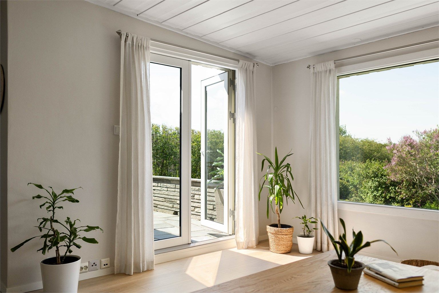 Fra stuen er det direkte utgang til en lun terrasse med skiferdekke og flotte utsyn mot den grønne hagen.. Balkongdøren har 2-lags pressglass, installert i 2026.