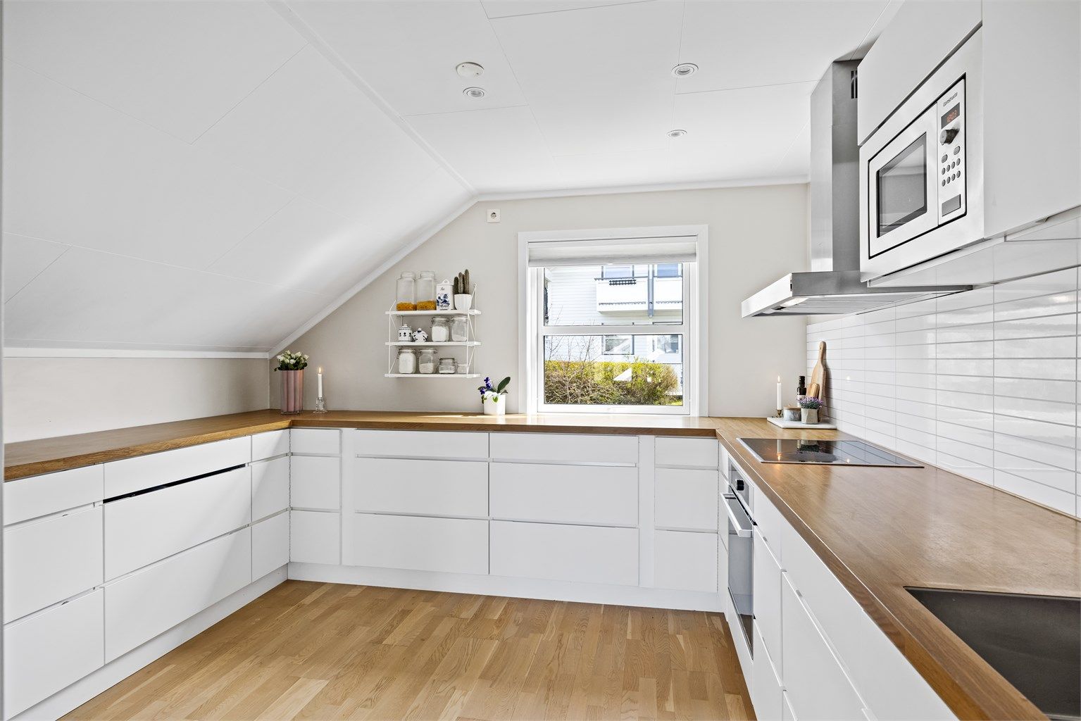 Innredning med glatte, hvite fronter og laminatbenkeplate.