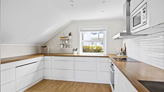 Innredning med glatte, hvite fronter og laminatbenkeplate.