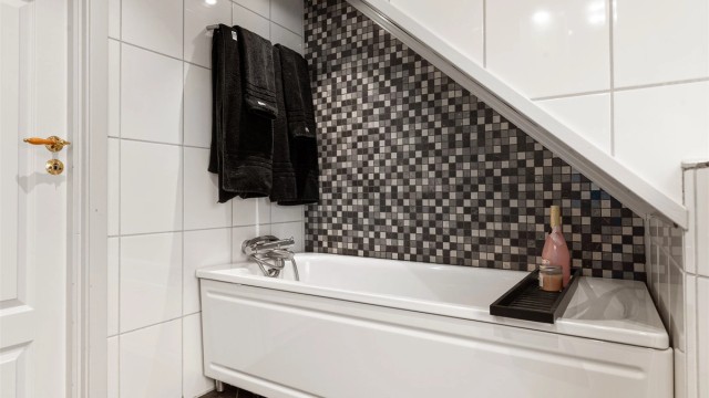 Baderom i andre etasje innredet med fliser, mosaikkdetaljer og innbygget badekar.