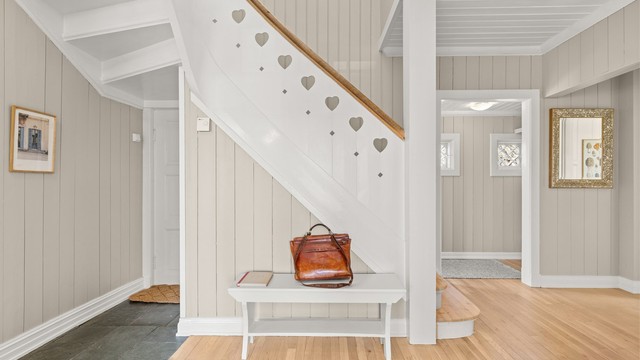 Den flotte trappen fanger blikket - med vakre detaljer og et håndverk som vitner om kvalitet og særpreg. De innskårne hjertene i rekkverket tilfører en personlig og sjarmerende dimensjon som gjør dette rommet helt spesielt
