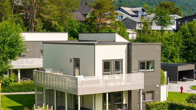 Bygget har en moderne arkitektur med ytterkledning av liggende trepanel.