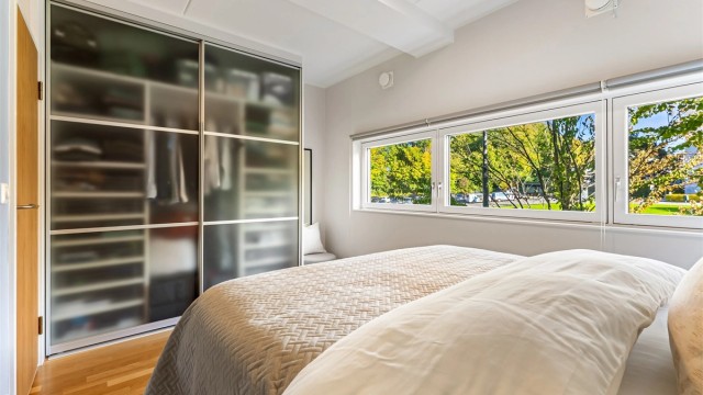 Rommet er innredet med en romslig skyvedørsgarderobe med frostede glassdører.