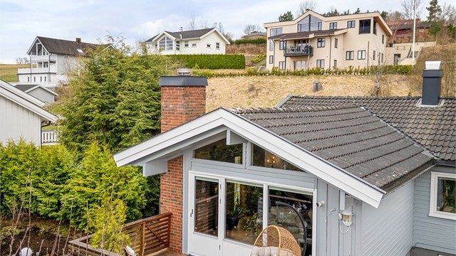 Tilbygget fra 1976 med de store vindusflatene gir stuen et moderne preg og god kontakt med uteområdet.