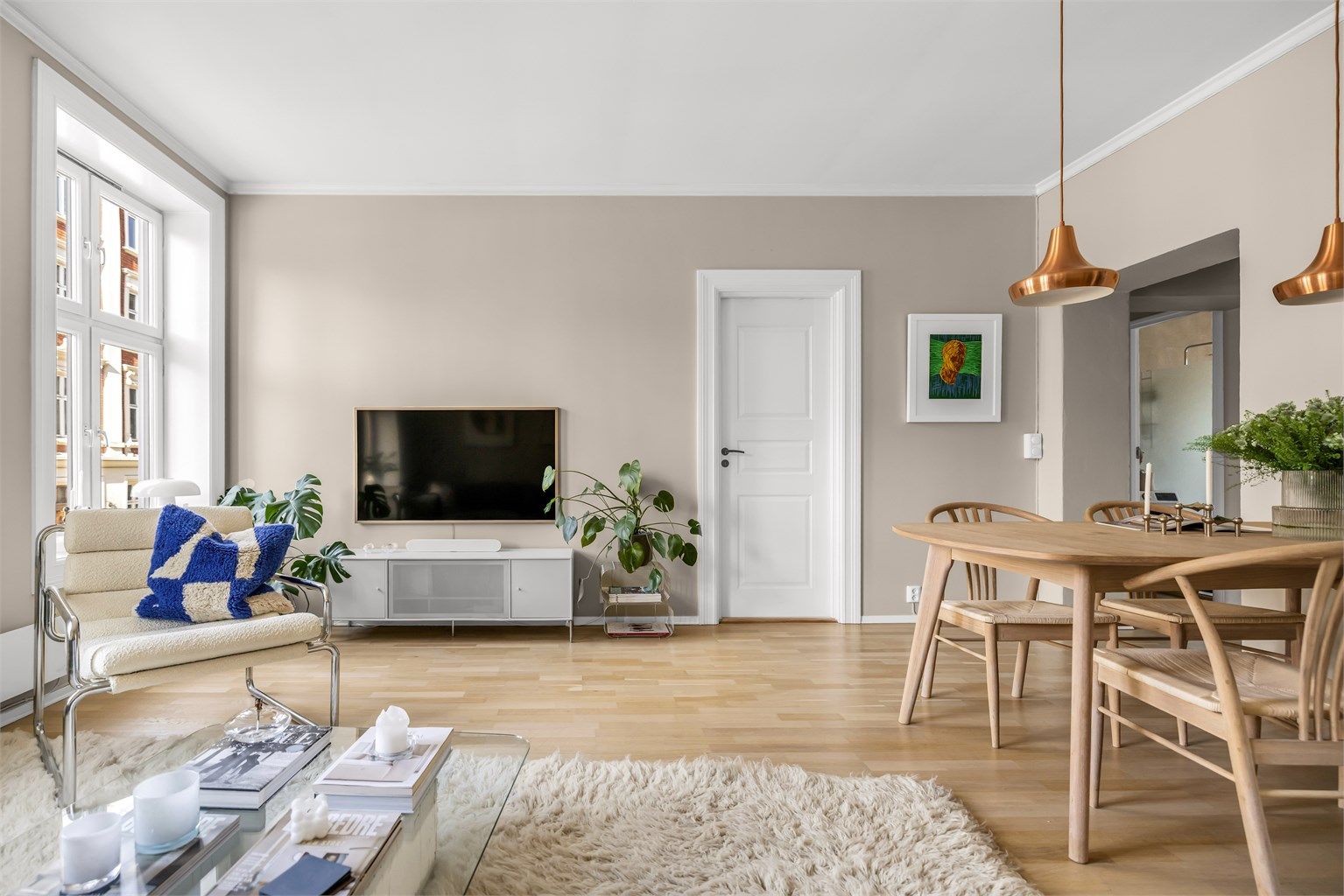 De store vindusflatene og den gode takhøyden bidrar til en lys og luftig atmosfære i rommet. 