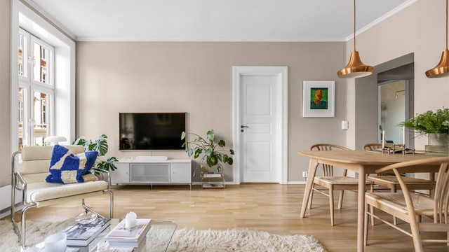 De store vindusflatene og den gode takhøyden bidrar til en lys og luftig atmosfære i rommet.