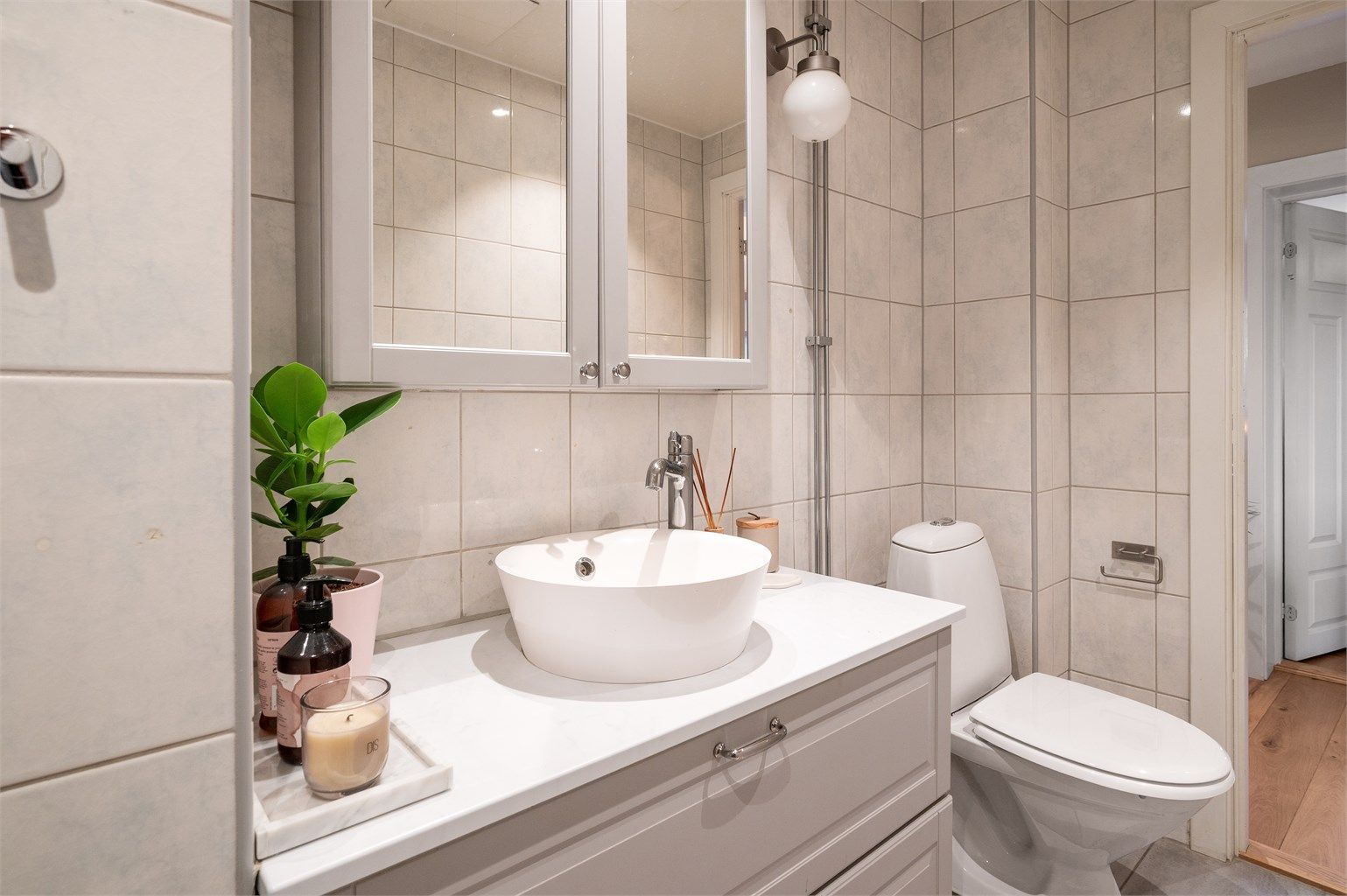 Badet er utstyrt med dusjhjørne med skyvedører i glass.