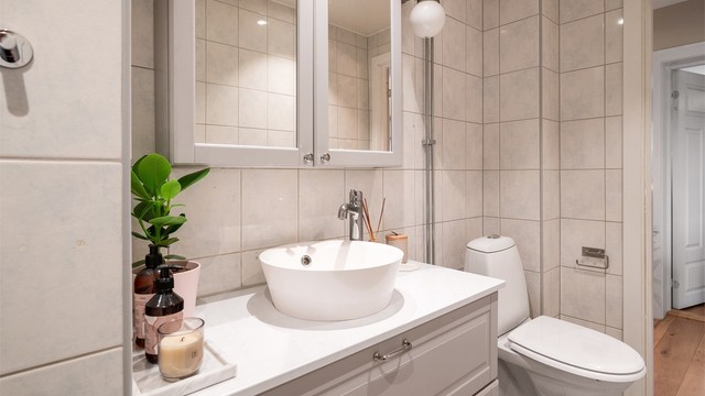 Badet er utstyrt med dusjhjørne med skyvedører i glass.