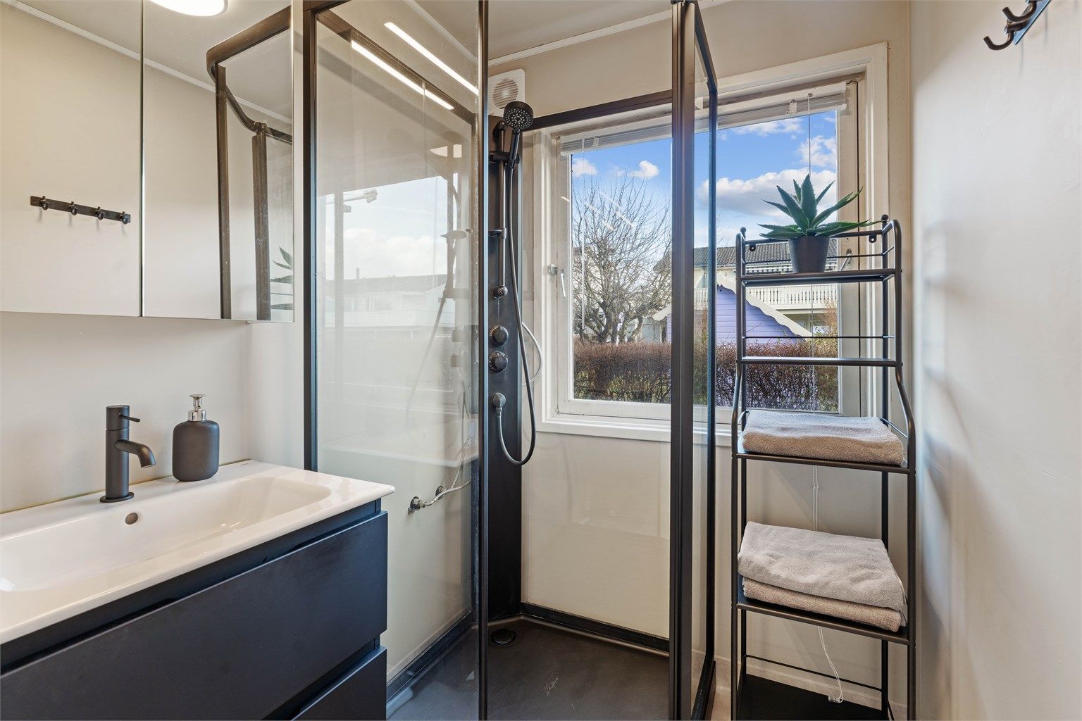 Badet i første etasje har dusjkabinett, servantinnredning og nytt gulvbelegg fra 2024.