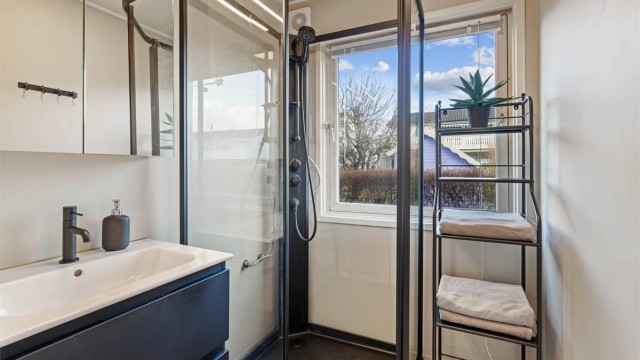Badet i første etasje har dusjkabinett, servantinnredning og nytt gulvbelegg fra 2024.