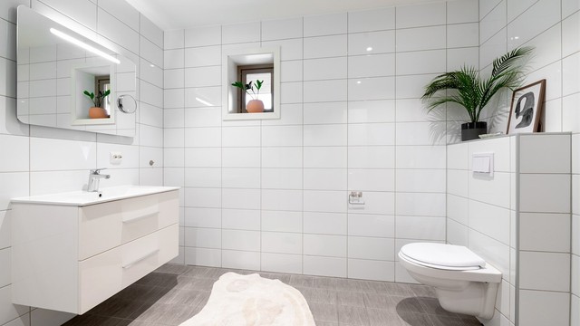 Badet er utstyrt med vegghengt toalett og servantinnredning.