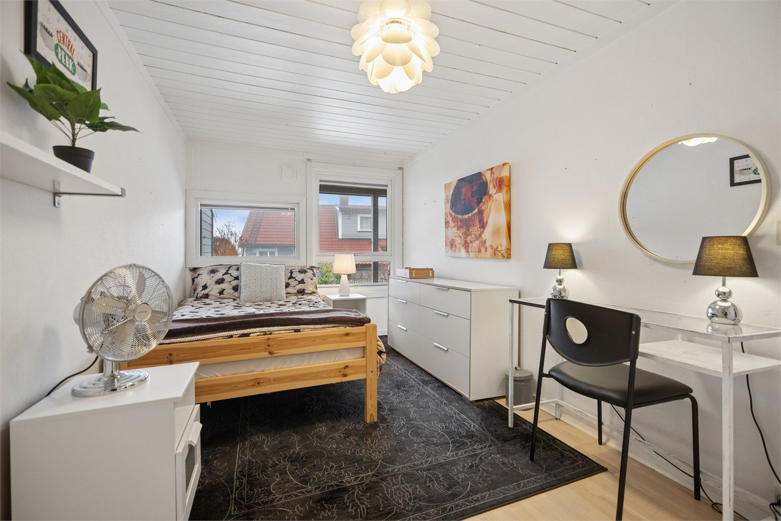 Romslig soverom med plass til stor seng, pult og oppbevaring.