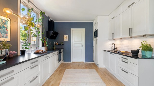 Et godt arbeidskjøkken med langstrakt benkeplate og godt med skapplass