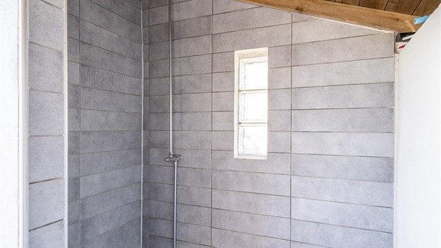 Den flislagte utedusjen er praktisk plassert ved bassengområdet.