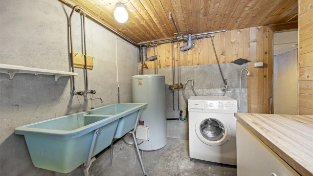 Vaskerom med opplegg for vaskemaskin, utslagsvask og varmtvannsbereder.