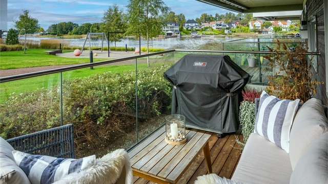 Uteplassen har glassrekkverk som skjermer mot vind og bevarer utsikten mot vannet.