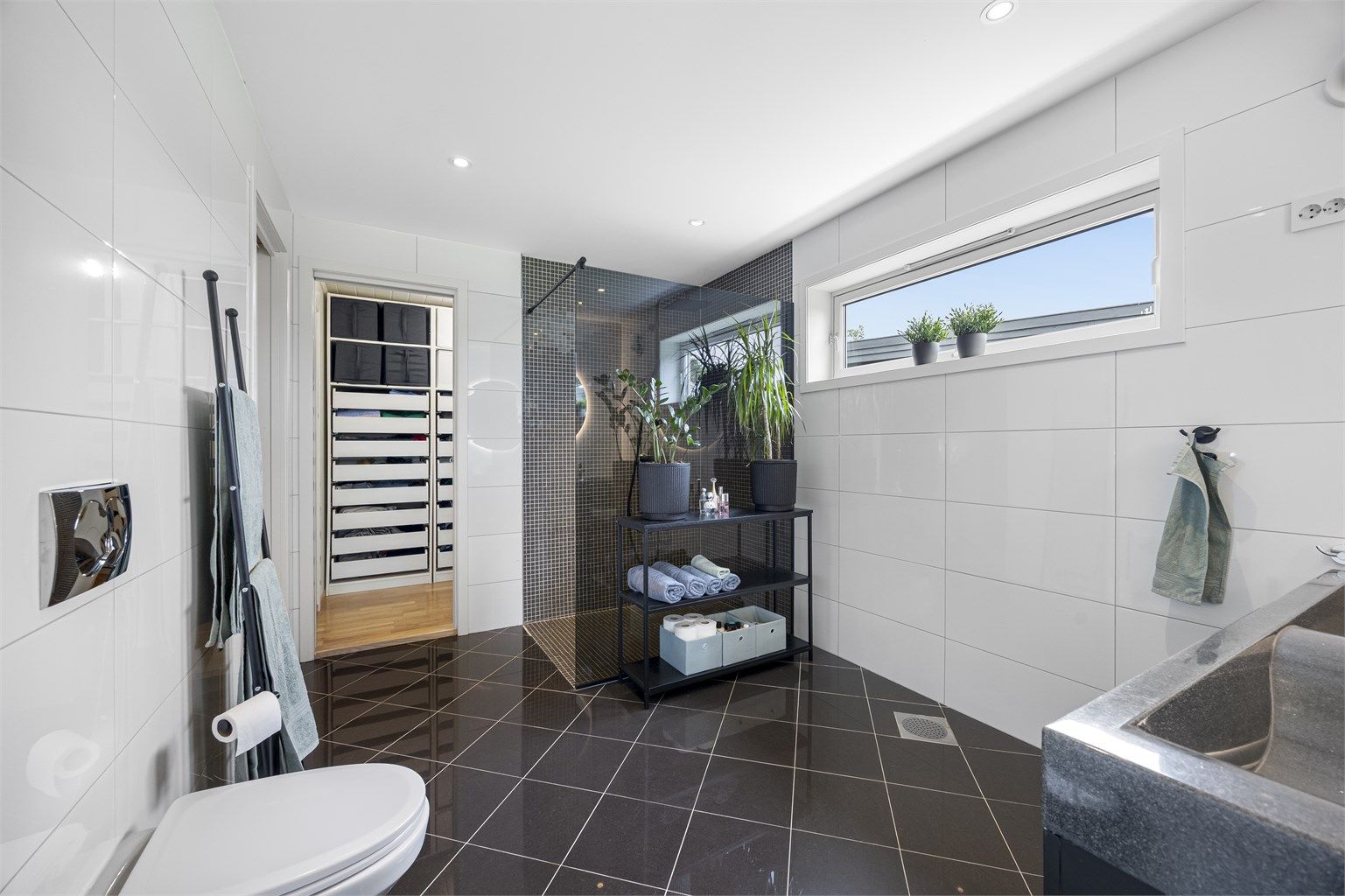 Fra badet er det tilkomst til garderobe og videre inn til vaskerom (vaskerom har tilgang fra gangen og utvendig i tillegg)