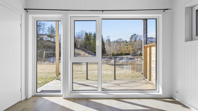 Fra stuen har du utgang til en terrasse på 9 m² med rekkverk i glass.