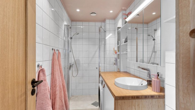 Badet har en moderne innredning med himling av malte plater, innfelte downlights og fliser med elektrisk gulvvarme