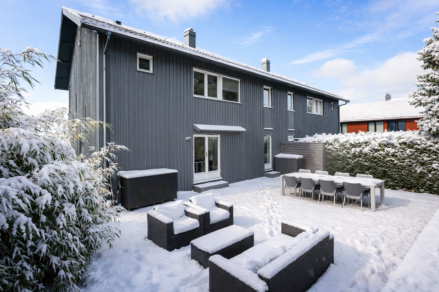 På baksiden av huset er det utgang til en stor terrasseplatting med god plass til sittegrupper / lounger - Vinterredigert bilde