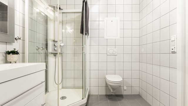 Innredet med vegghengt servantinnredning, speil med lys, dusjkabinett og toalett. Det er opplegg for vaskemaskin.