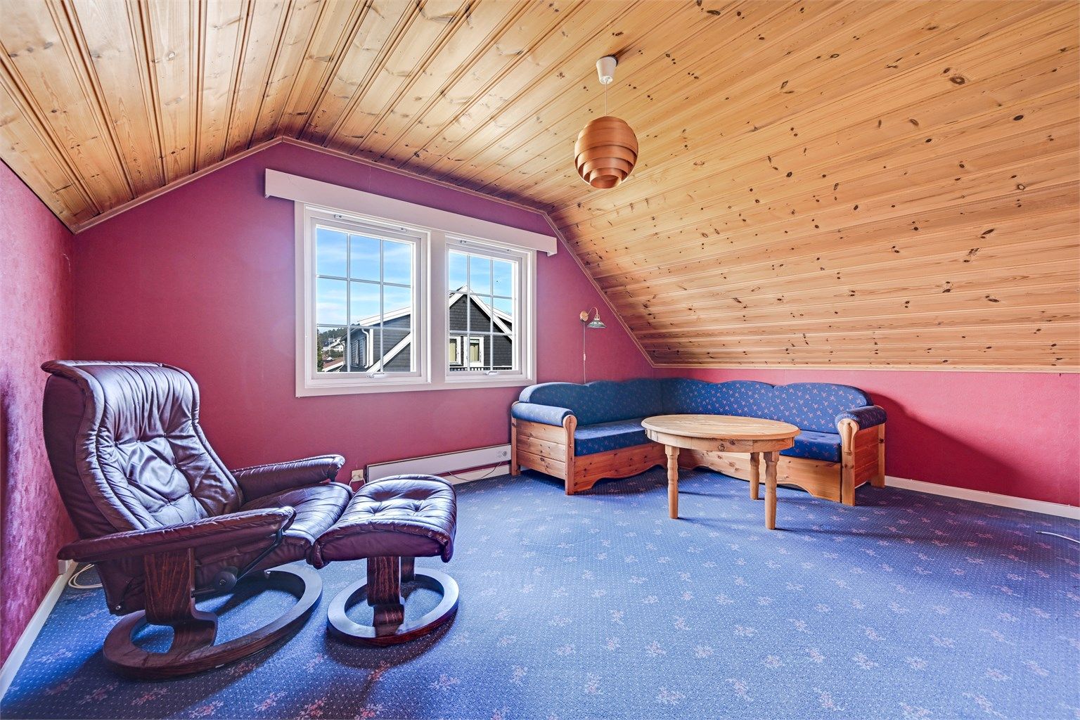 Loftstuen har teppebelegg på gulvet og panel i taket.