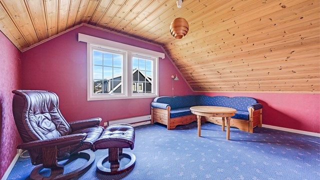 Loftstuen har teppebelegg på gulvet og panel i taket.