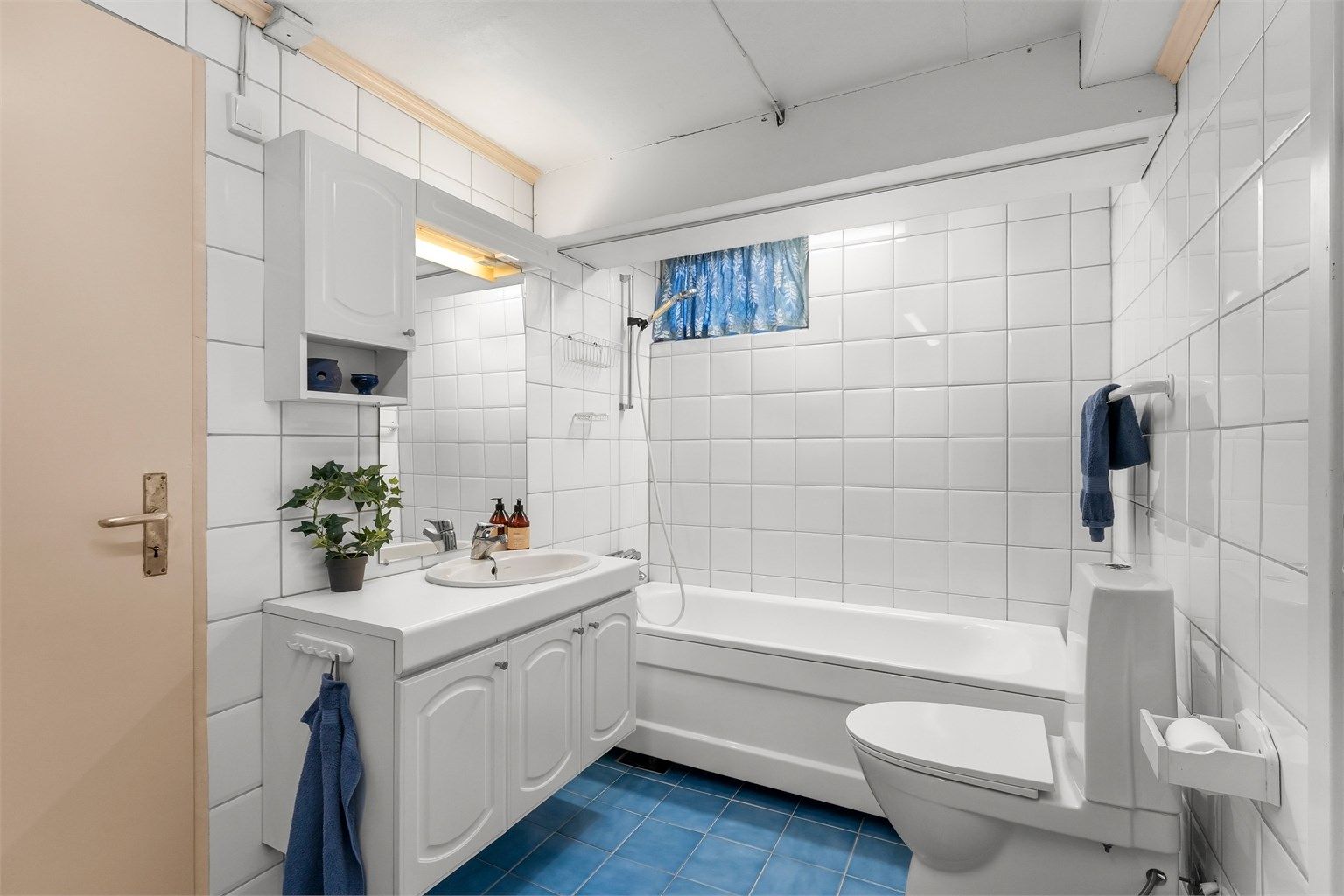 Badet i kjelleren er fra 1994 og har flislagt gulv med gulvvarme og badekar.