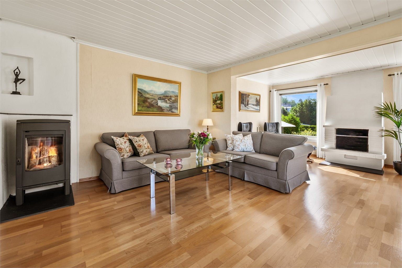 Lys og luftig stue med to sittegrupper, sofaområde samt spiseplass.