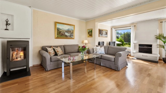 Lys og luftig stue med to sittegrupper, sofaområde samt spiseplass.