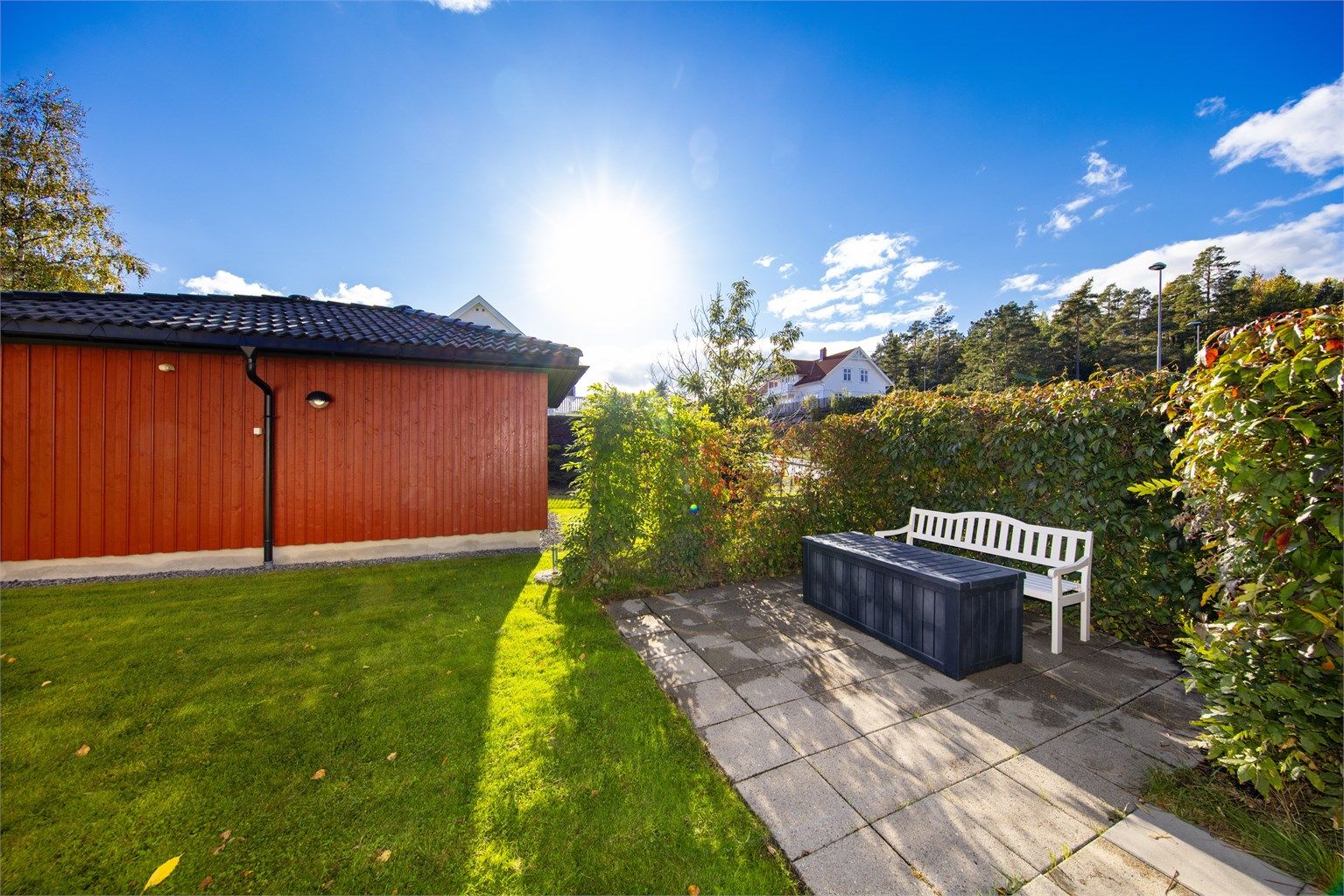 Mellom boligen og uthuset er det laget en skjermet uteplass.