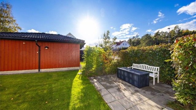 Mellom boligen og uthuset er det laget en skjermet uteplass.