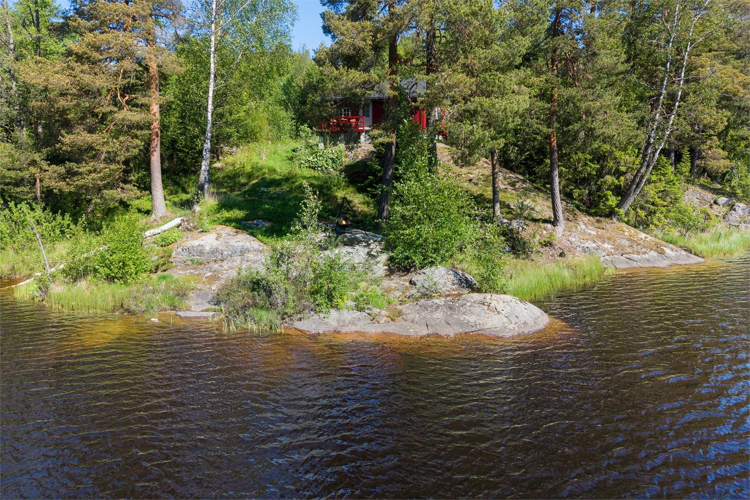 Tomten grenser direkte til vannet, med gode muligheter for både bading og fiske.