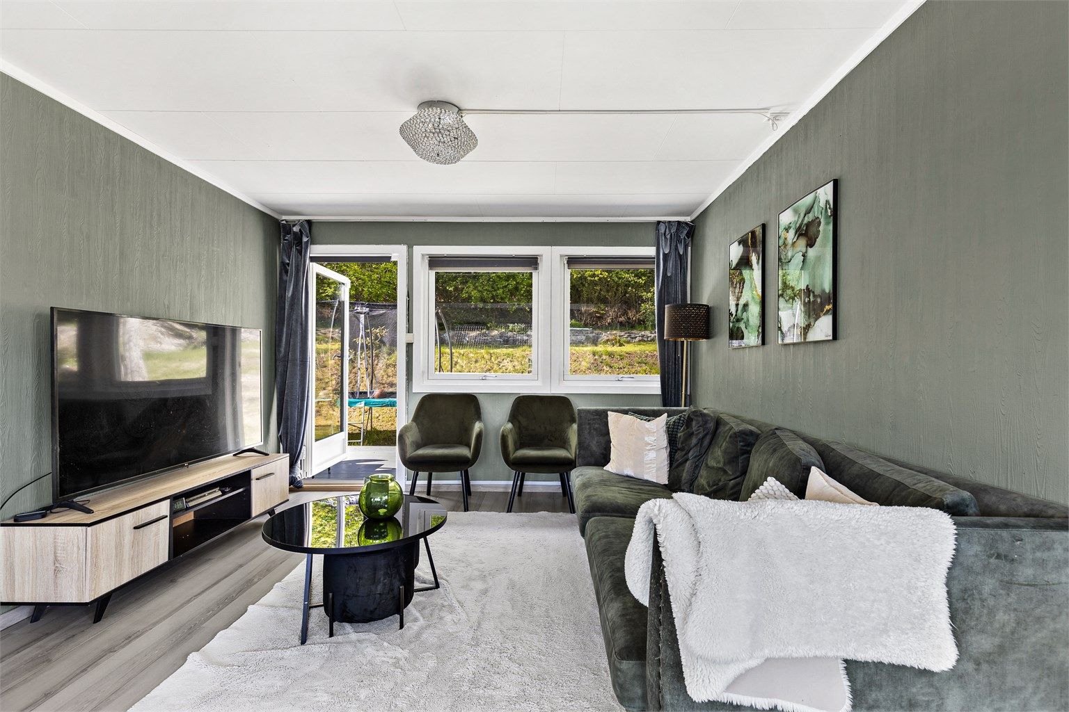 Stuen er av god størrelse med plass til sofa, salongbord og TV-seksjon. Her er det utgang til en stor terrasse med hage.