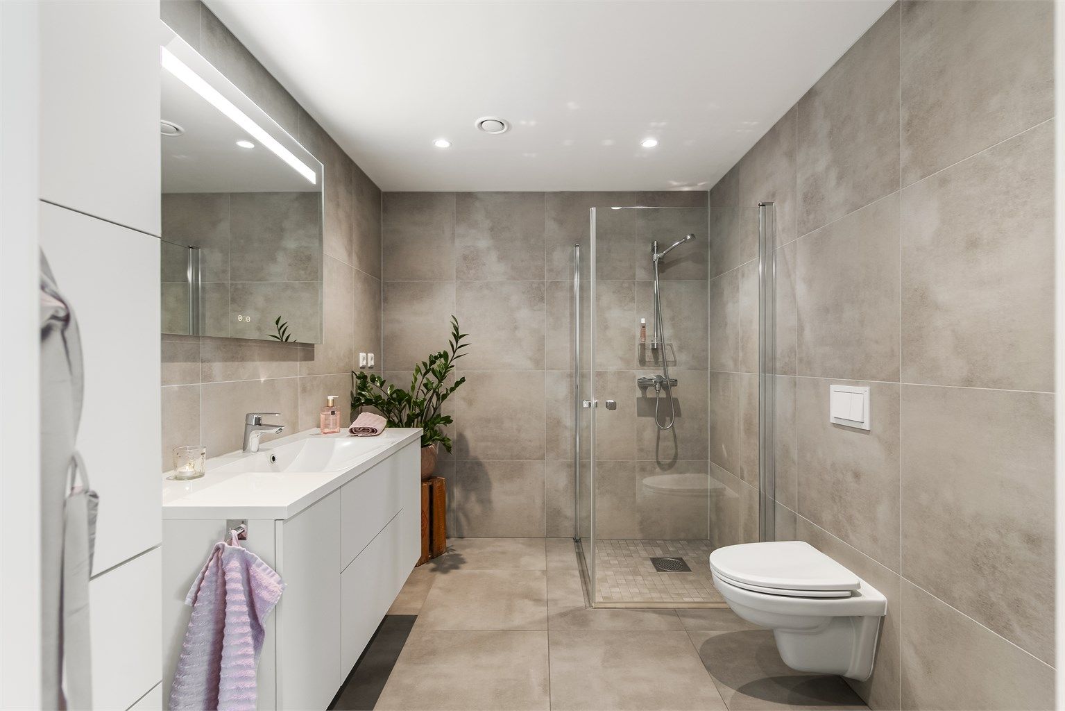 Delikat, flislagt bad med gulvvarme. Innredningen er fra Sigdal og inkluderer høyskap for ekstra oppbevaring.